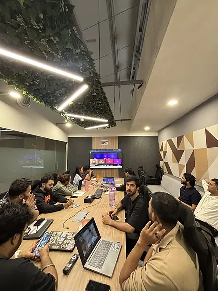 A group seated around a long table in a meeting space.